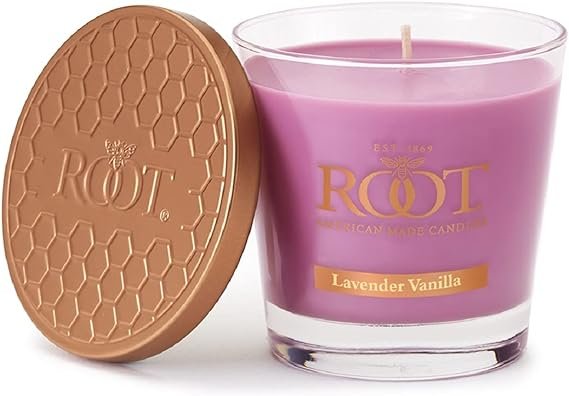 A glass jar of purple Lavender Vanilla scented beeswax candle with a brown honeycomb-patterned lid embossed with "ROOT".